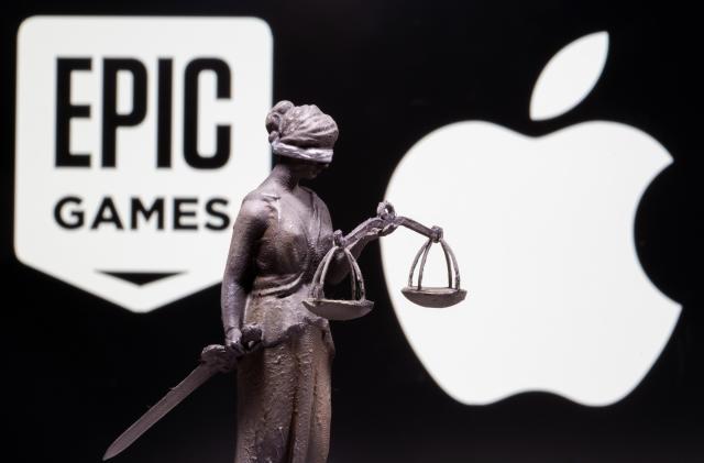 3D printed Lady Justice figure is seen in front of displayed Apple and Epic Games logos in this illustration photo taken February 17, 2021. REUTERS/Dado Ruvic/Illustration