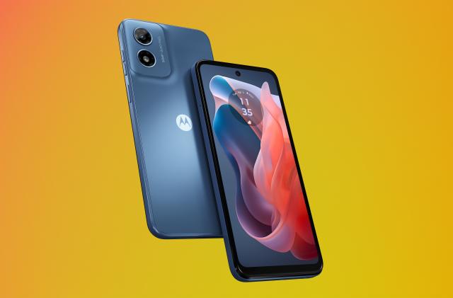 Product marketing image of the Moto G Play (in blue with a blue and red wallpaper). Two phones (one front-facing and one back-facing) sit in front of an orange-yellow gradient background.