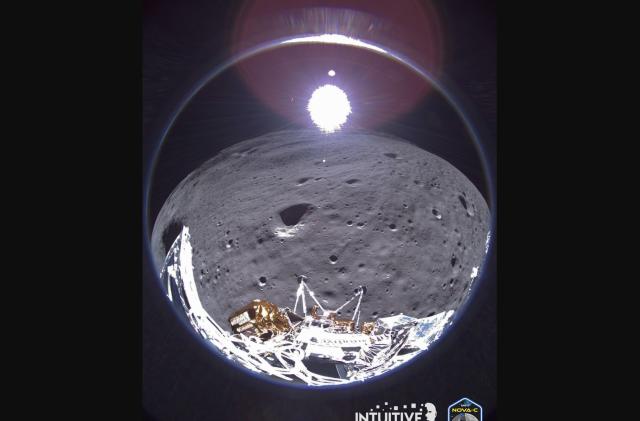 A wide angle view from the Odysseus moon lander showing a portion of the spacecraft, the moon, and Earth in the faraway distance