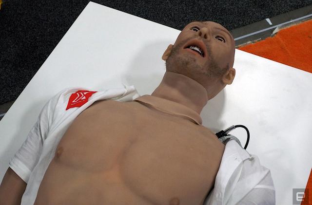 Image of the Adam-X medical training robot, an artificial human body laying on a white dais with the shirt open.