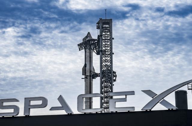 SpaceX's Starship on the launchpad and the SpaceX logo.