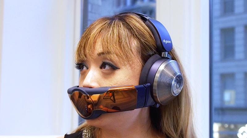 A woman wearing the Dyson Zone headphone and air filter combo unit.