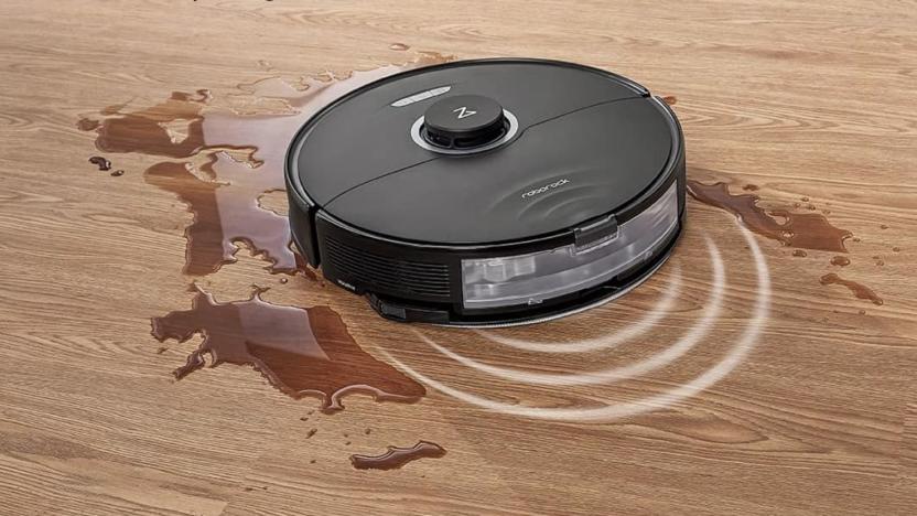 A robot vacuum and mop cleaning up some liquid on a floor.