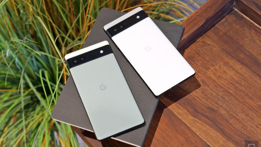 Top down view of the sage and white Pixel 6a next to each other, on top of book on a wooden surface.