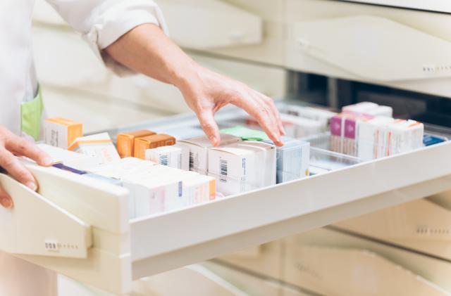 Close up of pharmacist hand taking meds from drawer