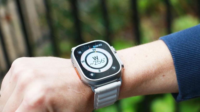 The Apple Watch Ultra on a wrist held in mid-air with a compass on its screen. The compass is showing the letter W with "~256 degrees" below it. 