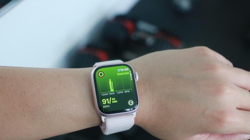 The Apple Watch Series 9 on a person's wrist in front of some gym equipment, showing the Exercise page of the Move rings app.